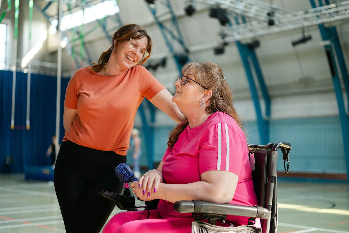 A support professional sharing a laugh with an adult in a community setting